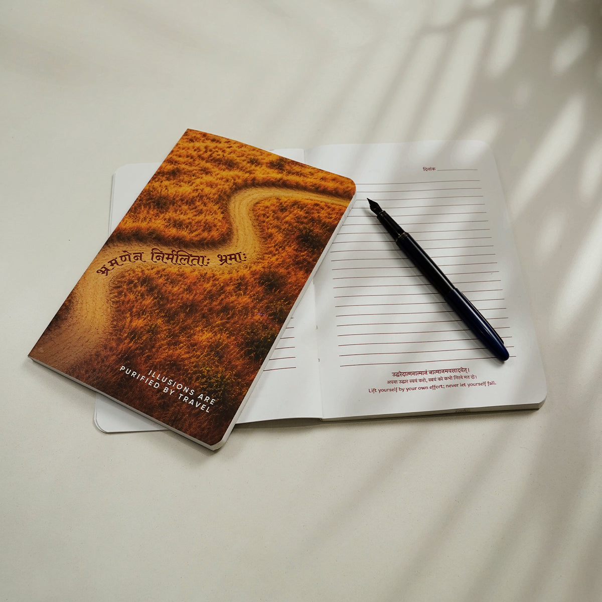 Prishthika Travel notebook open to a lined page with a दिनांक line and a shloka at the foot