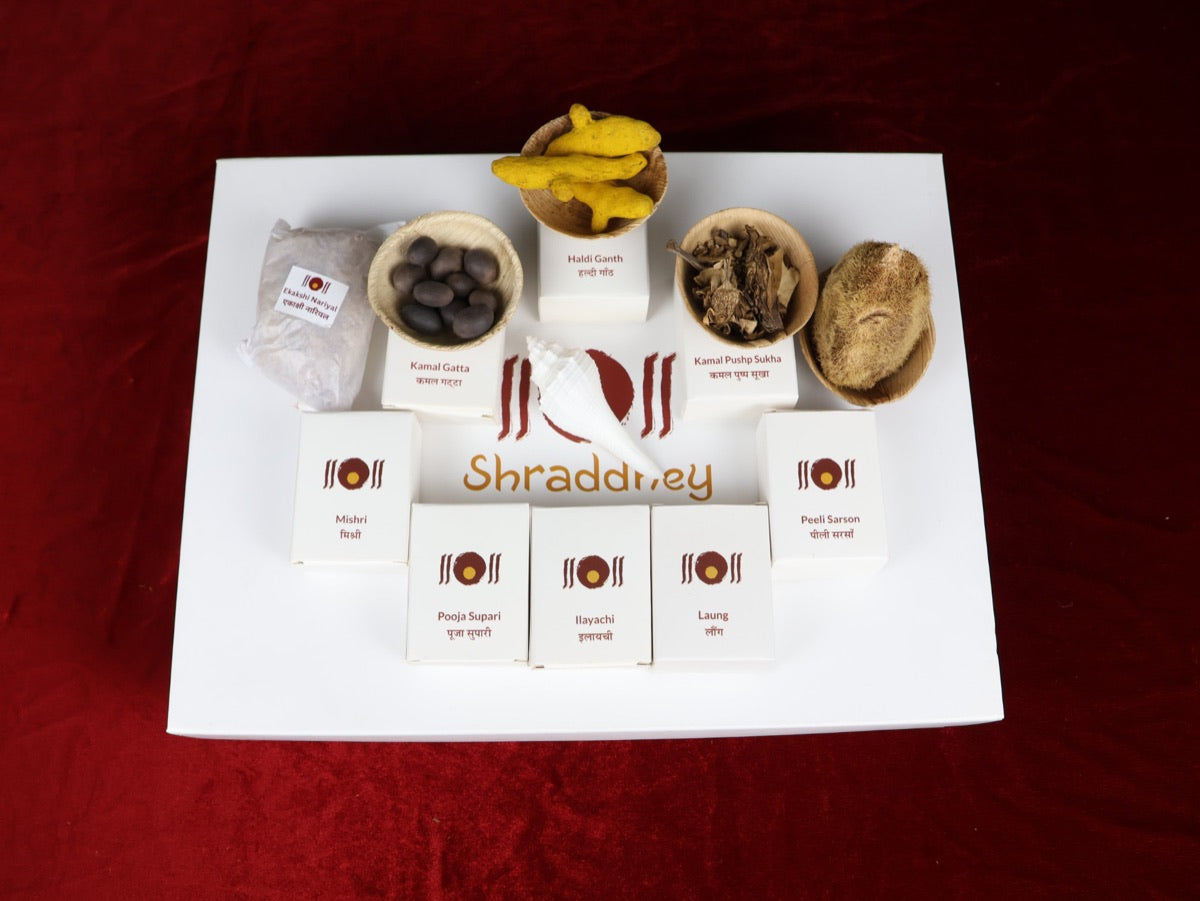 Arpan items from the box: Haldi Ganth, Kamal Gatta and Kamal Pushp in leaf bowls, Ekakshi Nariyal, Shankh, and Mishri, Pooja Supari, Ilayachi, Laung and Peeli Sarson boxes